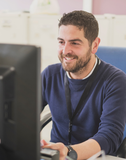 Man sitting a computer smiling